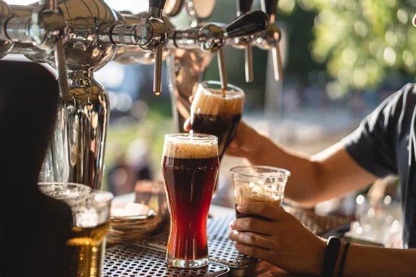 Barman giet een donker bier close-up — Stockfoto