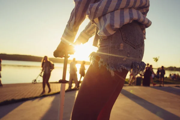 Beautiful female hands hold the scooter by the handles. — Stock Photo, Image