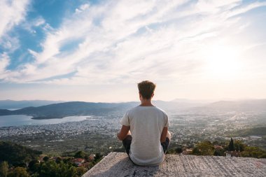 Adam arka kıyı kenti olduğunu buna çatının kenarında oturur.