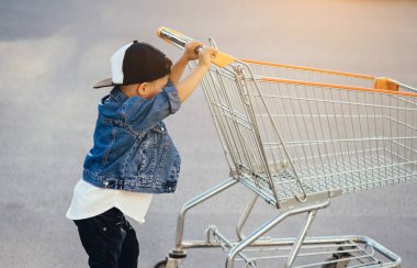 Küçük bir çocuk ve park yerinde büyük bir araba