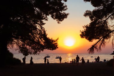 Akşam sahilde insanlar dinleniyor. Günbatımı.