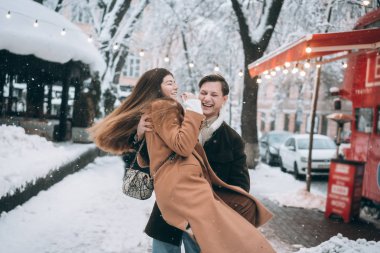 Genç adam bir güzel kız onun kollarında tutar.