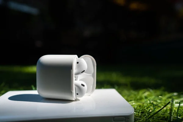 Wireless headphones and powerbank lie on the grass — Stock Photo, Image