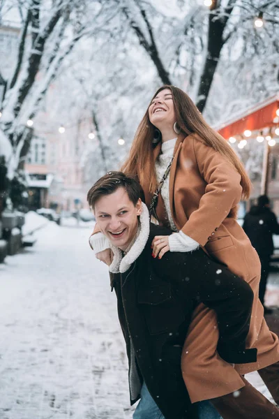 Όμορφο νεαρό ζευγάρι έχει τη διασκέδαση σε ένα χιονισμένο δρόμο — Φωτογραφία Αρχείου
