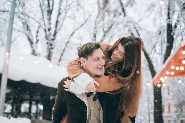 Belo jovem casal se divertindo em uma rua nevada — Fotografia de Stock