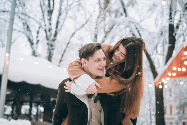 Mooie jonge paar plezier op een besneeuwde straat — Stockfoto