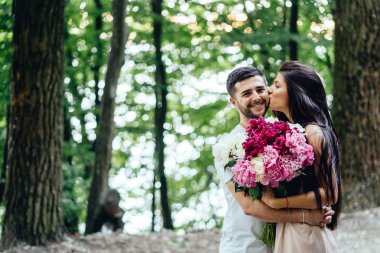 Genç, mutlu bir çift bir yaz parkta yol boyunca yürüyüş.