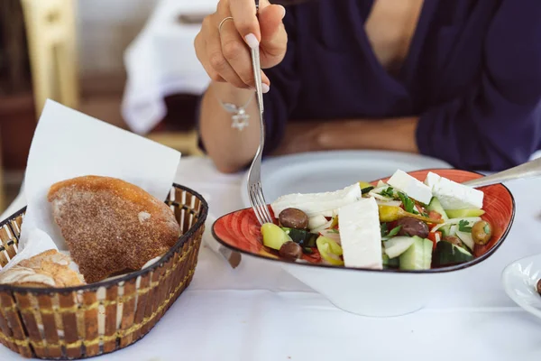 Χωριάτικη Σαλάτα, γυναικεία χέρια κρατούν ένα πιρούνι. — Φωτογραφία Αρχείου