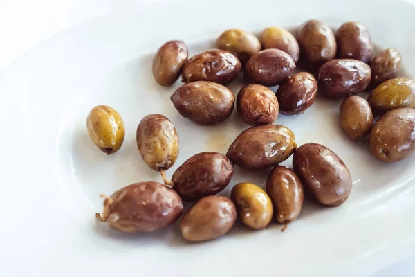 На тарелке лежат большие, маринованные греческие оливки . — стоковое фото