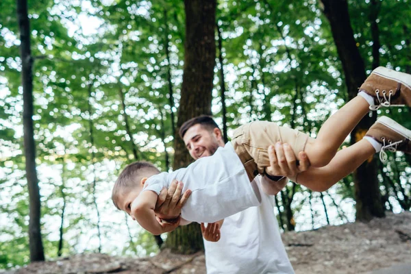Pai feliz está circulando nos braços de seu filho . — Fotografia de Stock