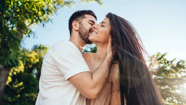 Junges Paar spaziert und küsst sich im Sommerpark. — Stockfoto