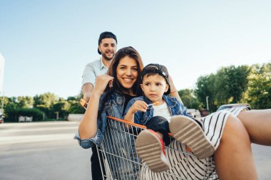 Genç Baba Anne ve oğlu bir arabası park yerinin üzerinde taşır. Aile eğleniyor.