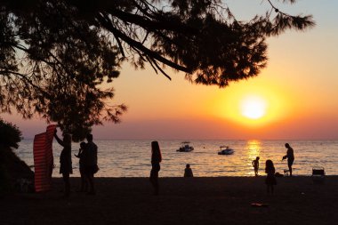 Akşam sahilde insanlar dinleniyor. Günbatımı.