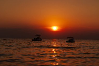 Güzel gün batımı. Mesafe iki küçük tekne görebilirsiniz.