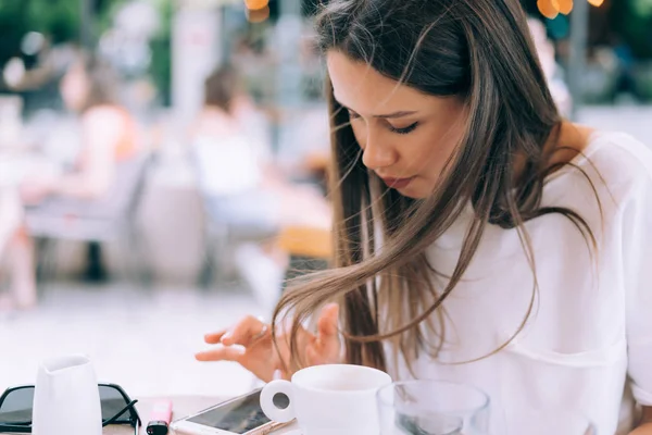 Attractive woman is sitting in a summer street cafe with a phone. — Stock Photo, Image