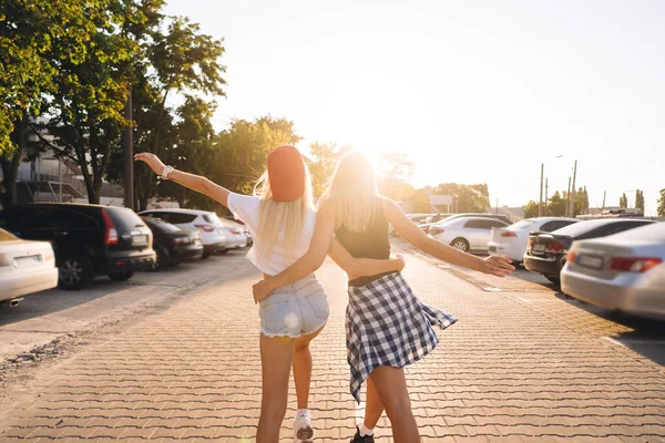 Två unga, sexiga tjejer promenader. Visa bakifrån. — Stockfoto