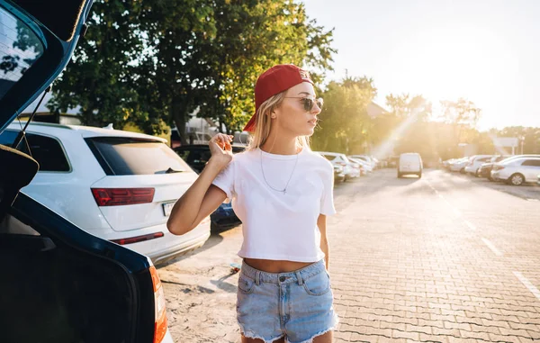 Красива молода жінка на парковці біля машини — стокове фото