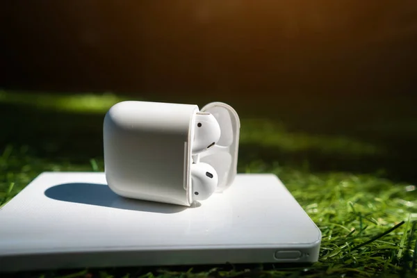 Headphone nirkabel dan powerbank terletak di rumput — Stok Foto