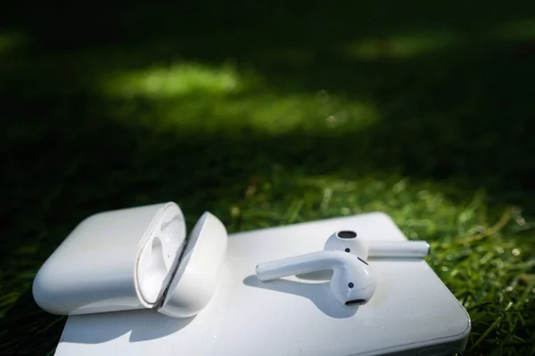 Headphone nirkabel dan powerbank terletak di rumput — Stok Foto