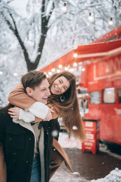 Mooie jonge paar plezier op een besneeuwde straat — Stockfoto