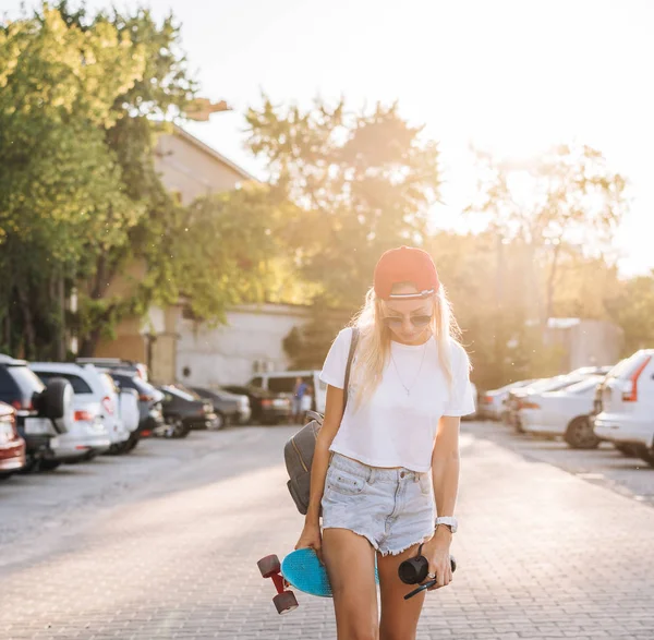 Молодая девушка со скейтбордом на парковке . — стоковое фото