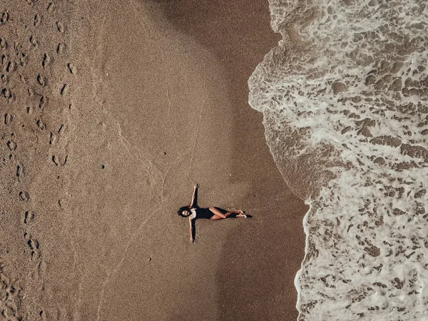 Vista aérea superior jovem deitado na praia de areia e ondas — Fotografia de Stock