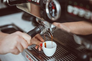 Professional espresso machine pouring fresh coffee into white ceramic cup clipart