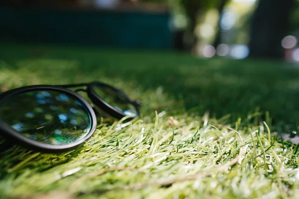 Óculos de sol estão na grama, ângulo próximo — Fotografia de Stock