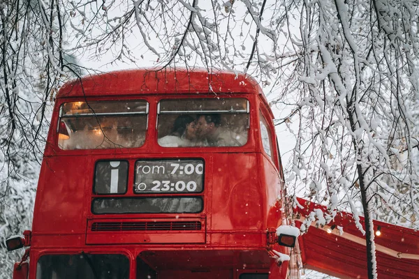 Loving young couple kissing in the red bus, enjoy each other — Stock Photo, Image