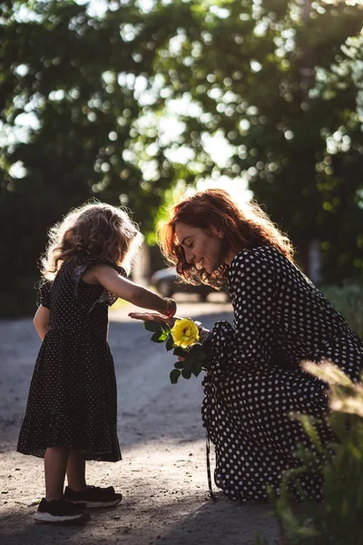 माँ और छोटी बेटी के साथ एक पीला गुलाब — स्टॉक फ़ोटो, इमेज