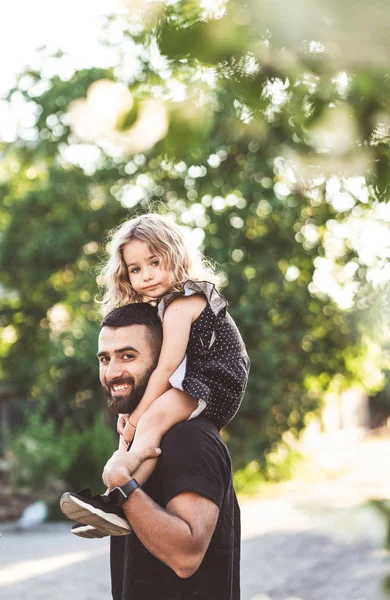 Una piccola figlia siede sulle spalle — Foto Stock