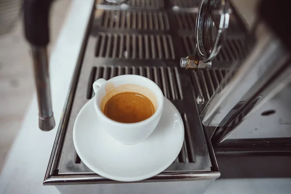 Крупный план стеклянной чашки с капучино и кофеваркой — стоковое фото