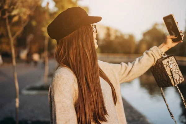 Fröhliches junges Mädchen im Park, das ein Selfie macht — Stockfoto