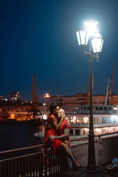 Guy et fille se serrant dans leurs bras sur un fond de port de nuit — Photo