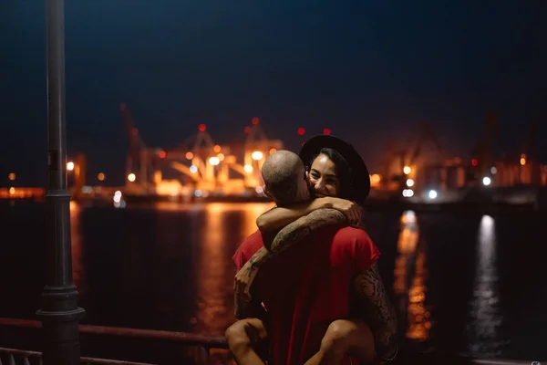 Хлопець і дівчина обіймають один одного на фоні нічного порту — стокове фото