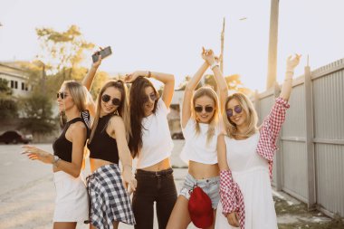 Beş genç kadın dans bir araba park