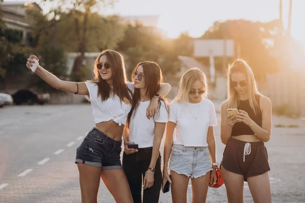 Quatro jovens mulheres tirando uma selfie e se divertir — Fotografia de Stock