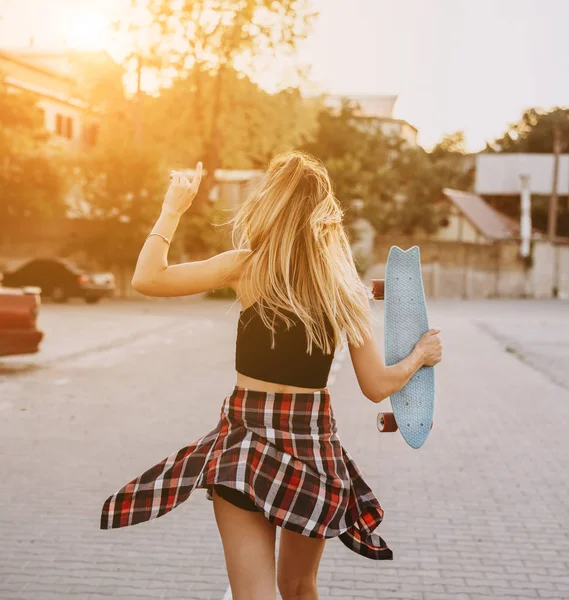 Young girl with a skateboard on a car park. — Stock Photo, Image