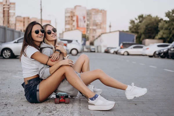 Δύο νεαρά κορίτσια, σέξι κορίτσια κάθονται στο έδαφος — Φωτογραφία Αρχείου