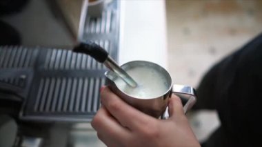 Barista haşlanmış süt yapıyor.