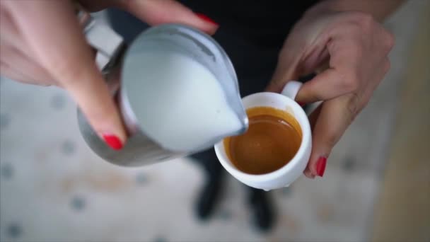 Mano de barista haciendo café con leche o capuchino vertiendo leche haciendo arte de café con leche — Vídeos de Stock