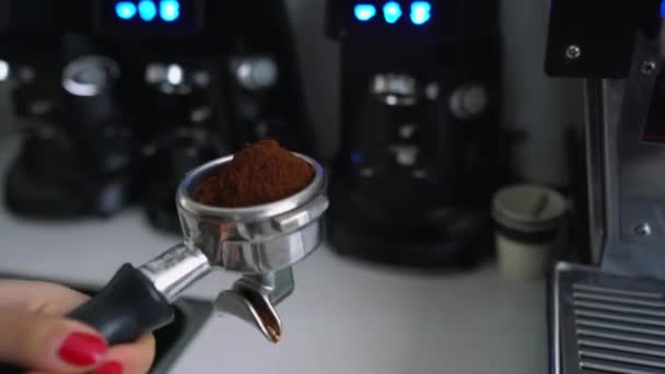Barista schudt portafilter met gemalen koffie — Stockvideo