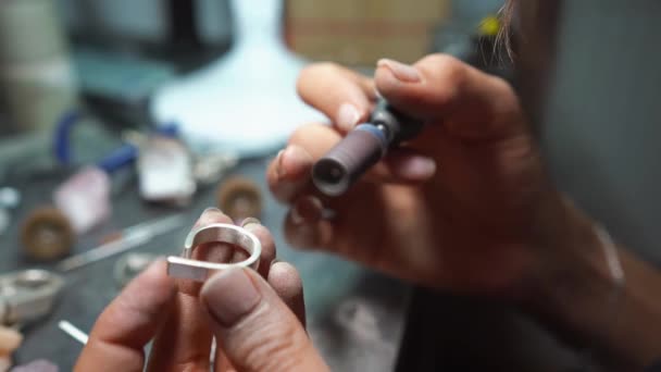 Дівчина майстер обробляє металеву пластину в домашній майстерні — стокове відео