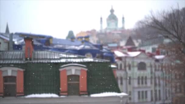 Άφθονη χιονόπτωση πέρα από την πόλη με τις στέγες των κτιρίων και των windows — Αρχείο Βίντεο