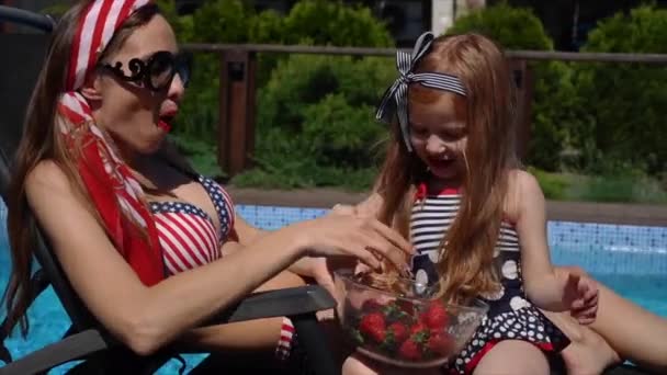 Young mother and her little daughter near the swimming pool — Stock Video