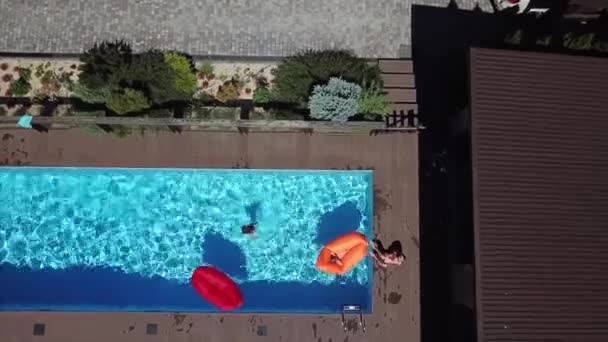 Mutter und Tochter ruhen sich auf dem Pool aus. — Stockvideo