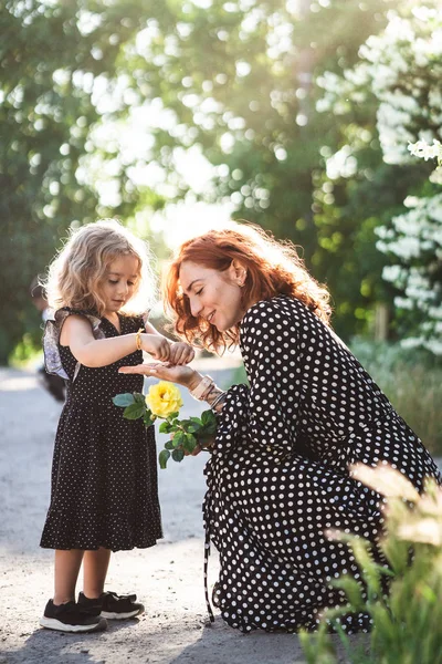 Mama i córeczka z żółty podniosłem się — Zdjęcie stockowe