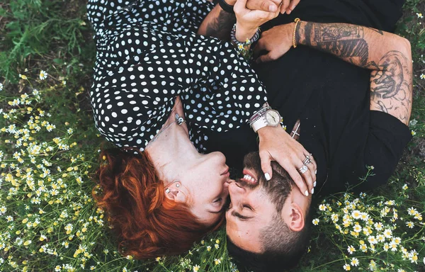 Genç çift sahada papatya ile yatıyor..