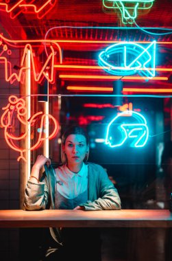 Güzel kız bir pencere kafe ve kamera bakar