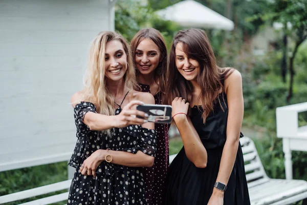 Tre flickor diskutera foto — Stockfoto